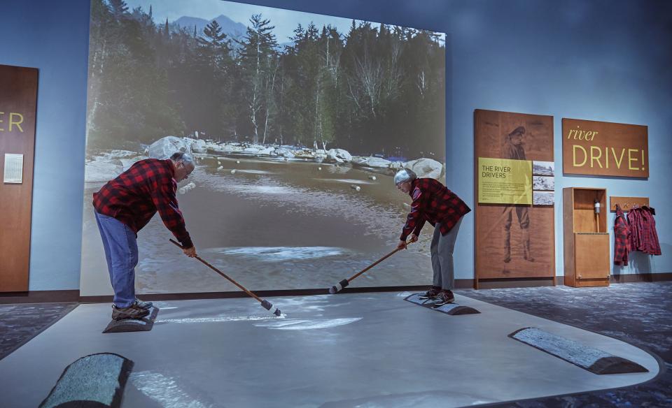 An older man and lady use the river driver log simulator