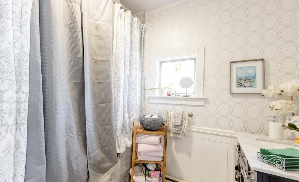 A bright white bathroom with light blue accents and orchids