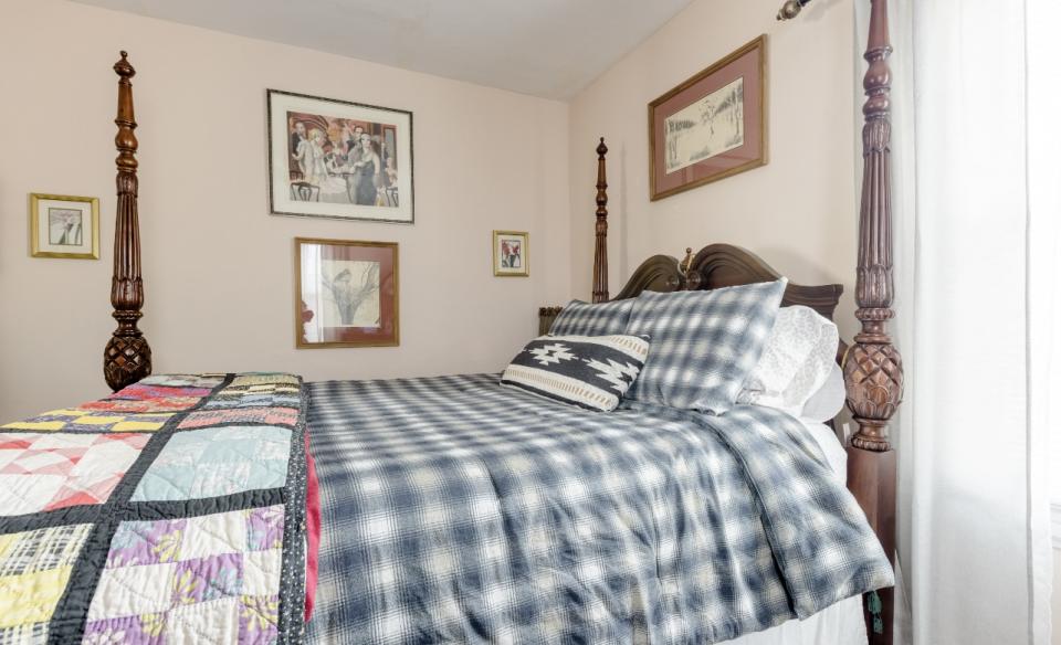 A guest room with a four post bed