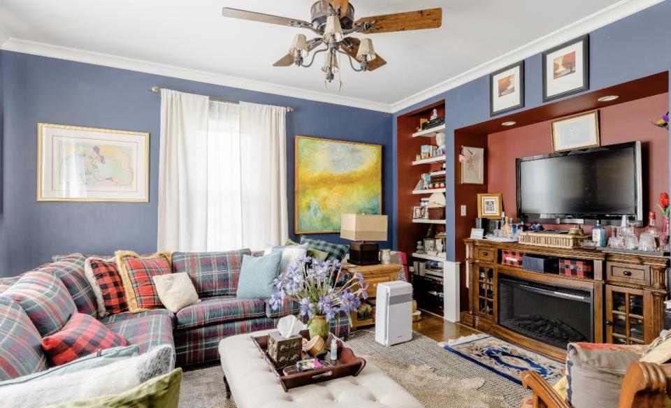 A comfortable blue living room with tv and fireplace.