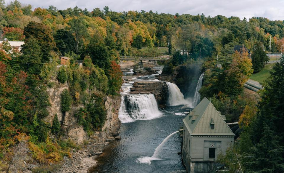 Water crashes over the falls with a building near by