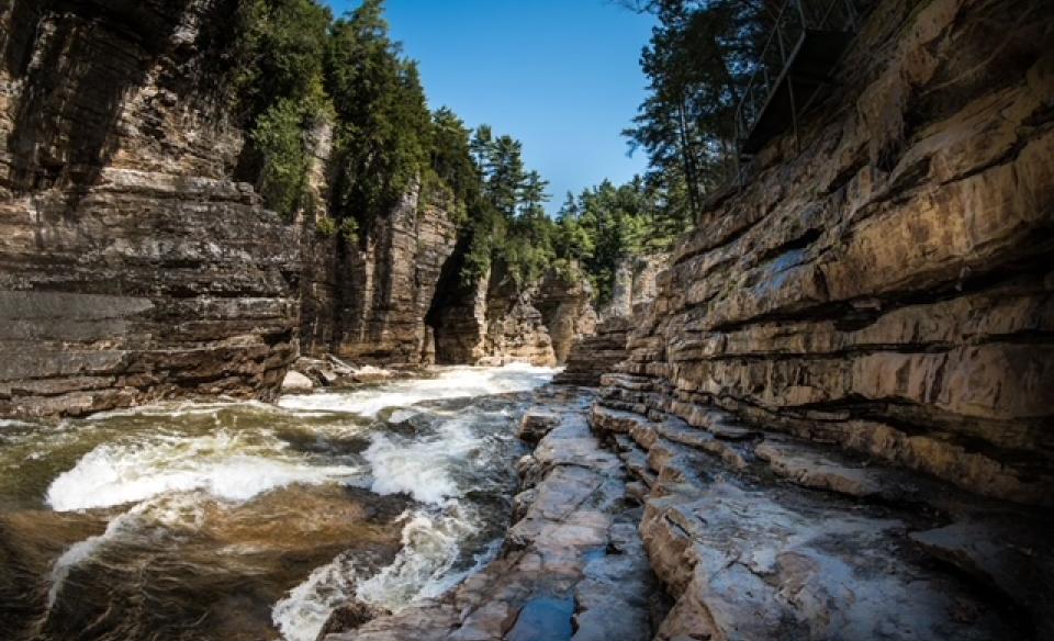 A view of the water rushing past with the towering walls of the gorge surrounding you