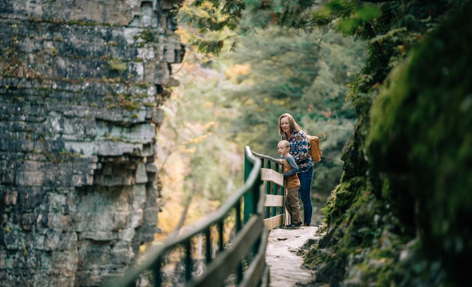 A mother and son peer over the railing into the chasm