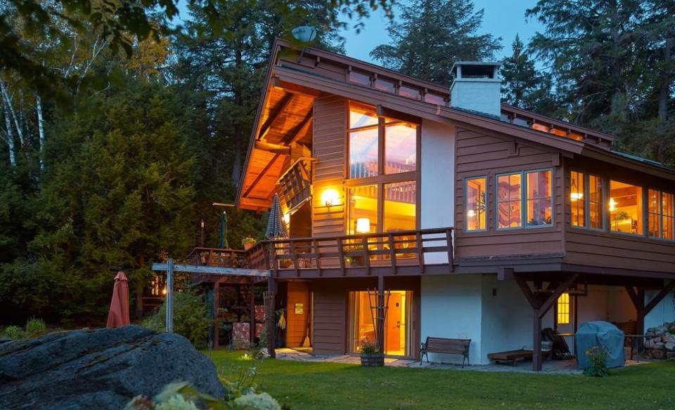 A large and warmly illuminated log cabin exterior.