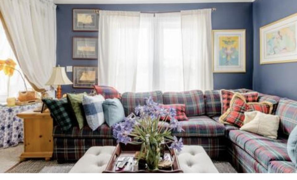 The formal sitting area with large window and plaid sectional couch